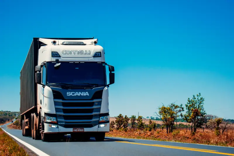 Fleet of freight trucks on a motorway at dusk